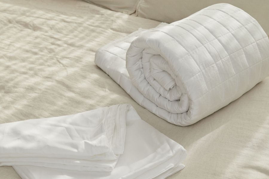 manta de peso abraza con cobertor sobre una cama